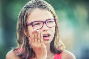 young girl experiencing an issue with her braces